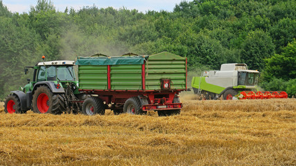 Traktor + Mähdrescher auf Feld bei der Ernte