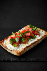 wholegraine ciabatta sandwich with sliced tomatoes, goat cheese, parsley. top view
