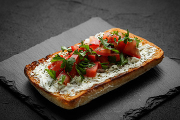wholegraine ciabatta sandwich with sliced tomatoes, goat cheese, parsley. top view