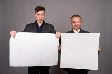 Mature Asian businessman and young Scandinavian businessman agai