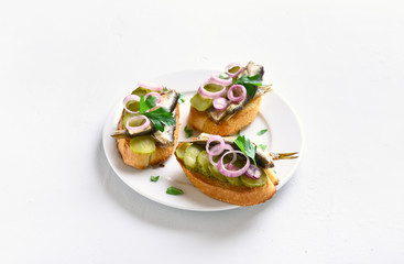 Sandwiches with sprats, marinated cucumber and onion