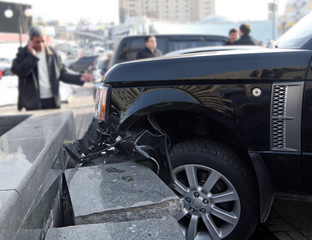 Car crash accident. Luxury car crashed into a stone fence.
