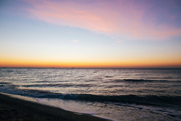 Beautiful sea waves foam closeup and pink sky in sunrise light on tropical island. Waves in ocean at sunset. Tranquil calm moment. Summer vacation. Copy space