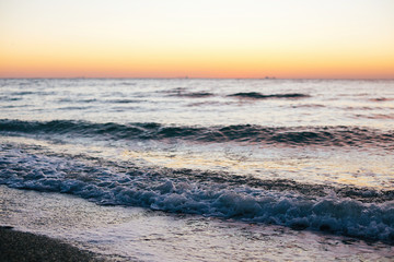 Beautiful sea waves foam closeup and pink sky in sunrise light on tropical island. Waves in ocean at sunset. Tranquil calm moment. Summer vacation. Copy space