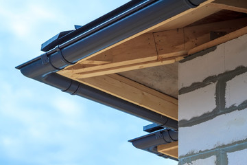 Fototapeta premium close up view of house under construction with holders for gutters water drainage system
