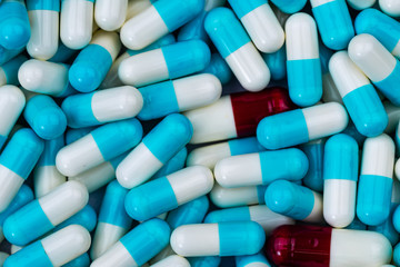 Bulk blue-white and red-white capsule pills. Contaminate in production line of pharmaceutical manufacturing. Drug interaction concept. Pharmaceutical industry. Pharmacy product background. Healthcare.