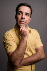 Portrait of handsome Persian man against gray background