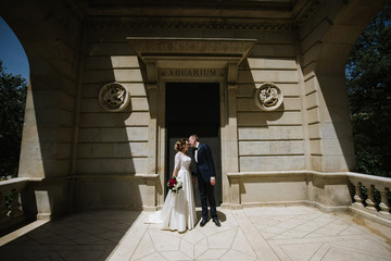 Bride and groom posing at the door of the building