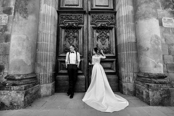 Bride and groom posing at the door of the building