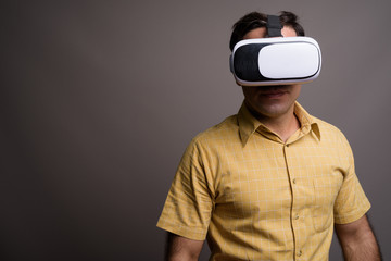 Portrait of handsome Persian man against gray background