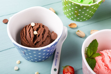 Homemade chocolate ice cream on light blue wooden background. Healthy summer food concept.