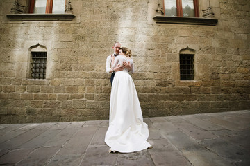 Bride and groom posing on city streets