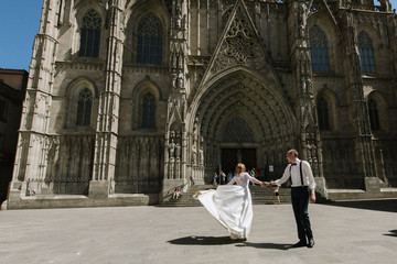 Bride and groom posing near the church of Santa Maria del Mar in Barcelona