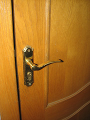 Wooden door with worn gold-plated door handle