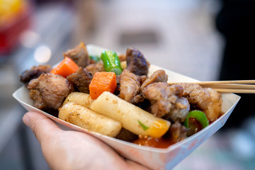 Pan-fried black pork meal in Korea traditional market, delicious korean food cuisine with carrot and shallot green onion, close up, copy space