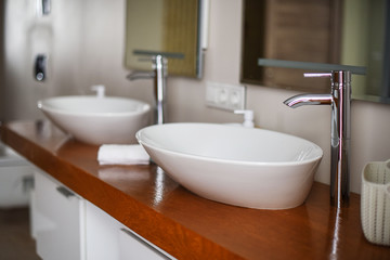 Naklejka na ściany i meble Modern bathroom interior. Modern stylish washbasins with chrome taps. Luxury lifestyle. Wood texture