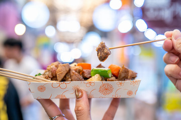 Pan-fried black pork meal in Korea traditional market, delicious korean food cuisine with carrot and shallot green onion, close up, copy space