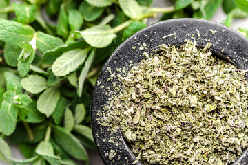 Dry mint, closeup in a mortar and fresh mint leaves, dried herb, top view
