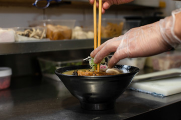 preparing and cooking japanese ramen with meat and vegetables