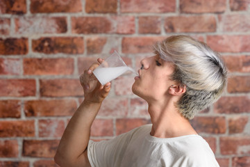 Vaper Smoke outdoor electronic cigarette near the brick wall. Young man smoking big cloud of steam