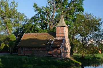 Fototapeta na wymiar Historical half-timbered church by the river - Poland, Zulawy, Wroblewo