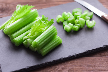 crushed celery stalks on stone Board on wooden background