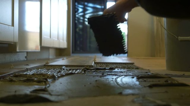 A flooring contractor trowling tile adhesive
