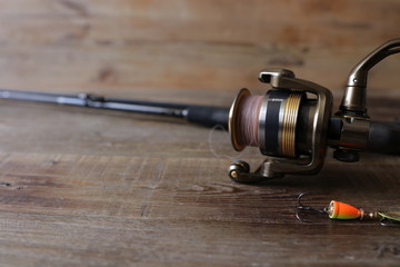 spinning with reel and lure on wooden background