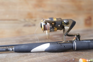 spinning with reel and lure on wooden background