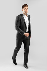 Going young businessman on grey background