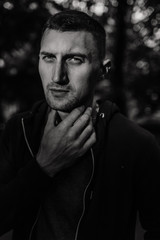 Portrait of the young thinking man holding his hand near the neck