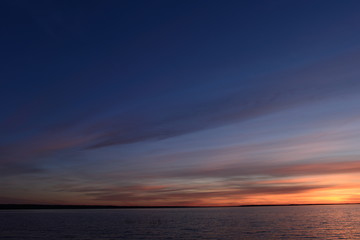Fototapeta na wymiar romantic sky at sunset blue in the twilight glow over the lake