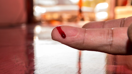 A finger on human hand is cut hurt and bleeding with bright red blood