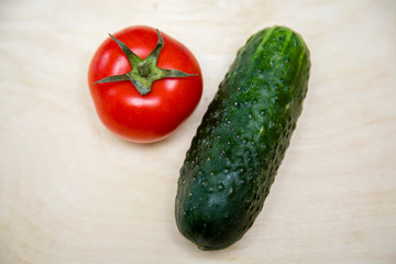 ripe vegetables cucumbers and tomatoes on an open background