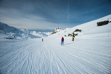 Skiers on a piste in alpine ski resort