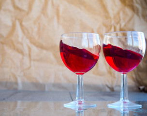 two glasses of red wine, champagne, cocktail on the background of old paper, near the cork of the champagne, female alcoholism, alcohol problem