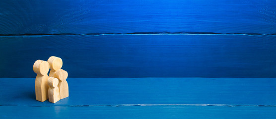 Wooden figurines of a young family on a white background. Concept of a young strong and healthy married couple. A loving couple expects the birth of a child. Pregnancy. banner, place for text