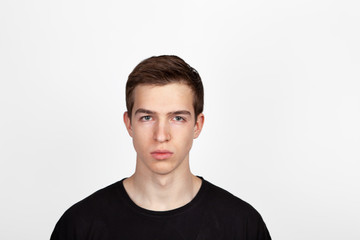 Portrait of a young handsome man in black t-shirt over white background.