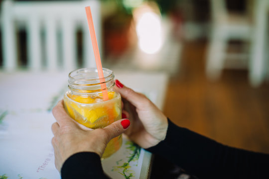lemon juice with woman hands with red manicure