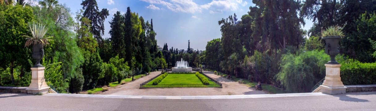 Athens, Attica / Greece - September 11, 2018: The garden with the marble fountain in front of the Zappeion Hall neo-classical building in the National Garden near Syntagma Square. Sunny day cloudy sky