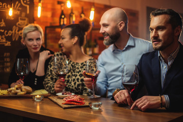 Group of friends having fun talk behind bar counter in a cafe