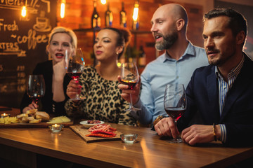 Group of friends having fun talk behind bar counter in a cafe