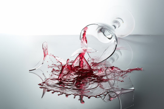 The breaking of a glass full of red wine