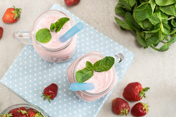 Healthy dessert concept. Fresh organic sugar free strawberry smoothie or milkshake with mint top view.