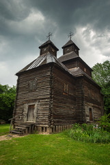 Fototapeta na wymiar Orthodox wooden church in the Ukrainian village under dramatic skies