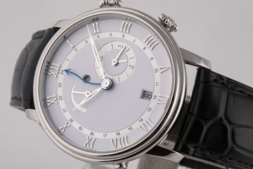 Silver wristwatch with white dial, silver clockwise, stopwatch and chronograph on black leather...