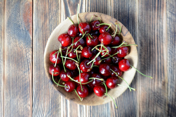 Cherries in a brown wooden bowl. Fresh organic summer berries