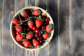 Strawberries and cherries in a wooden bowl. Fresh organic summer berries