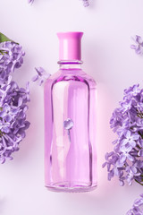 Obraz na płótnie Canvas perfume bottle with lilac flowers on white background