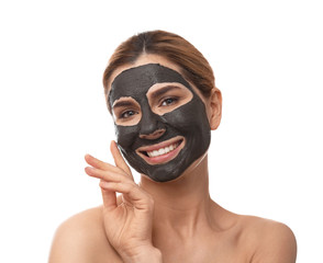 Beautiful woman with black mask on face against white background